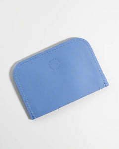 the back side of the Small Hours Leather Card Case in Sky Blue laying on an angle against a white background