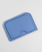 Load image into Gallery viewer, the Small Hours Leather Card Case in Sky Blue laying flat on a white background tilted on an angle