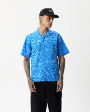 Load image into Gallery viewer, the Afends Men&#39;s Icebergs Short Sleeve Shirt in Arctic on a model posing with his hands at his sides and his head turned to his left shoulder
