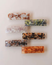 Load image into Gallery viewer, six rectangular hair barrettes displayed in a ladder laying on a neutral background shot from an overhead angle

