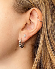 Load image into Gallery viewer, the Horace Gemma Stud Earring in silver shown in an ear in the second piercing along with a hoop earring in the first hole
