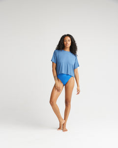 model standing wearing the Richer Poorer Women's Night Knit Tee in Blue Horizon and blue briefs posing with right knee bent and hand on thigh