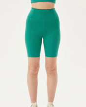 Load image into Gallery viewer, close up of the front of the Girlfriend Collective Bike Short in Saguaro worn by a model