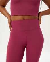 Load image into Gallery viewer, close up view of a model wearing the Girlfriend Collective Ultralight Legging in Rhododendron posing with her hands on her hips
