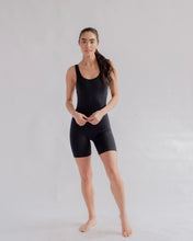 Load image into Gallery viewer, the Girlfriend Collective Bike Unitard in black worn by a model posing standing
