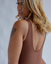 Load image into Gallery viewer, close up of the back view of the Girlfriend Collective Bike Unitard in Earth on a model looking over her shoulder
