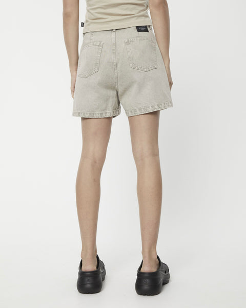 the back view Afends Women's Seventy Threes Denim Shorts in Faded Cement on a model