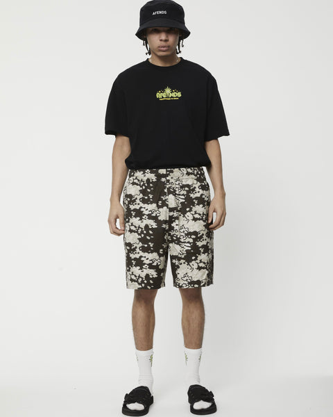 the Afends Men's Ninety Eights Short in Earth Camo on a model standing staring into the camera