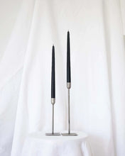 Load image into Gallery viewer, a pair of Socco Designs Taper Candles in black in two tapers of varying heights against a white sheet background