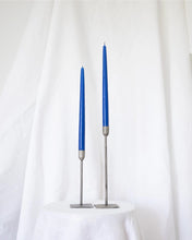 Load image into Gallery viewer, a pair of Socco Designs Taper Candles in bright blue in two tapers of varying heights against a white sheet background