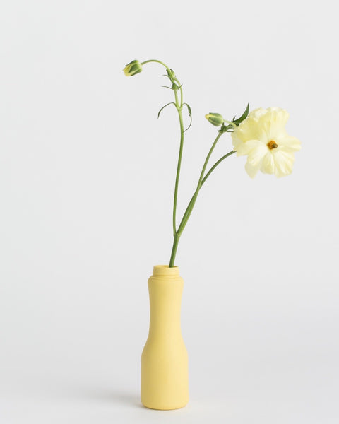 Middle Kingdom Drinkable Yogurt Bottle Vase in butter with a yellow flower