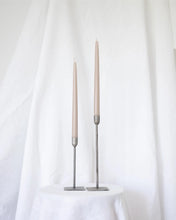 Load image into Gallery viewer, a pair of Socco Designs Taper Candles in oat in two tapers of varying heights against a white sheet background