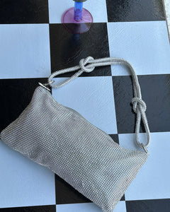 the Slouchy Crystal Shoulder Bag in Silver laying on a checkerboard background