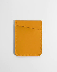 the Small Hours Slim Leather Card Holder in Yellow laying flat on a white background