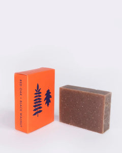 the ALTR Sage & Sea Salt Bar Soap sitting on its side beside its box against a neutral background