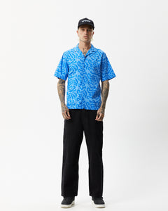 the Afends Men's Icebergs Short Sleeve Shirt in Arctic on a model standing straight on staring into the camera
