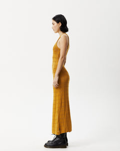 side view of the Afends Women's Femme Dress in Mustard on a model standing with her hands by her sides