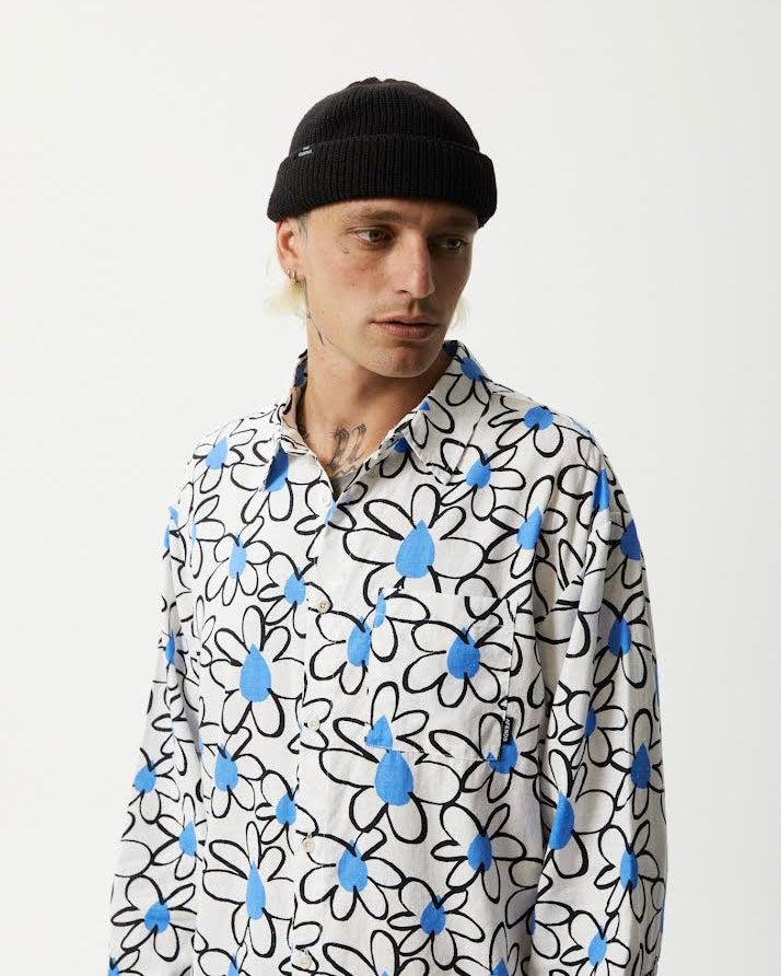 the Afends Men's Waterfall daisy printed Long Sleeve Shirt in White on a model posing on a slight angle with his head toward his left shoulder