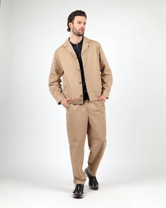 the Wemoto Men's Ethan Jacket in Khaki on a model posing with his hands in the pockets of his khaki pants in front of a neutral background