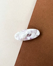 Load image into Gallery viewer, the Horace Lina Hair Clip in pearly lilac shot from overhead in the center of a brown and cream surface
