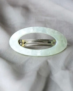 the Horace Maria Hair Clip in mint shot from above laying on grey fabric