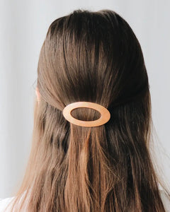 the Horace Maria Hair Clip worn in a half up style by a model with long brunette hair shot at the back of her head