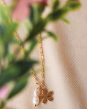 Load image into Gallery viewer, the Horace Filoro Necklace laying against a neutral textured background with some greenery out of focus in the foreground
