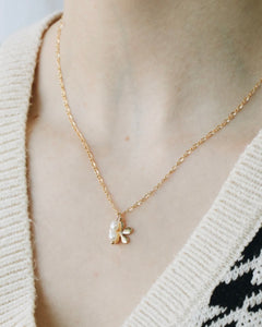 a close up shot of the Horace Filoro Necklace worn by a model wearing a v neck sweater 