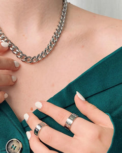 the Horace Sparka Ring in silver worn by a model posing with her hand on her chest