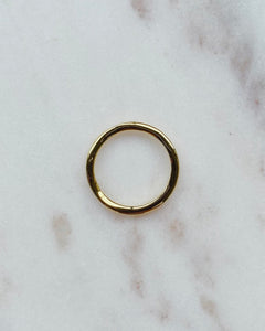 Horace Wavy Ring in gold shot from above laying flat on a marble surface