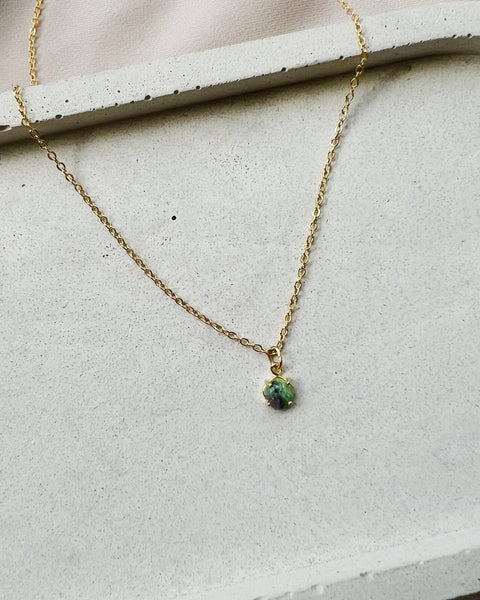 the Horace Zoto green agate Necklace laying on a neutral background
