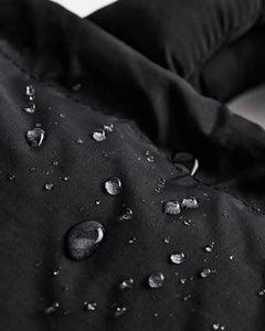a close up of the Ölend Mini Ona Soft Bag covered in water droplets demonstrating its water resistance