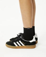 Load image into Gallery viewer, Afends Women&#39;s Essential Socks in black on a model worn with adidas gazelles
