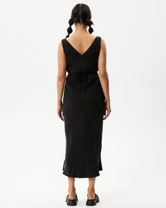 back view of the Afends Women's Gemma Dress in Black on a model posing in front of a white background