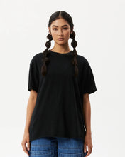 Load image into Gallery viewer, the Afends Women&#39;s Slay Oversized Tee in Black on a model posing against a white background
