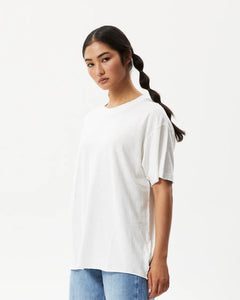 Afends Women's Slay Oversized Tee in White on a model posing in front of a white background