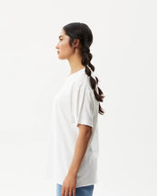 Load image into Gallery viewer, side view of the Afends Women&#39;s Slay Oversized Tee in White on a model posing in front of a white background
