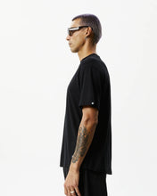 Load image into Gallery viewer, side view of the Afends Men&#39;s Classic Hemp Retro Tee in Black on a model posing in front of a white background
