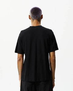 back view of the Afends Men's Classic Hemp Retro Tee in Black on a model posing in front of a white background