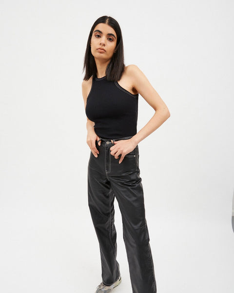 the Dr. Denim Women's Echo Jean in Black Coat Contrast on a model posing with her thumbs in her belt loops against a neutral background