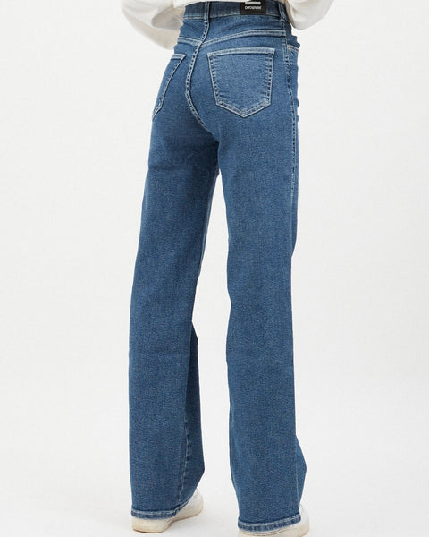 close up back view of the Dr. Denim Women's Moxy Jean in Cape on a model standing in front of a neutral background