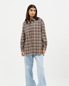 the Dr. Denim Women's Molly Shirt in Ocean Check on a model standing in front of a neutral background looking off to the side