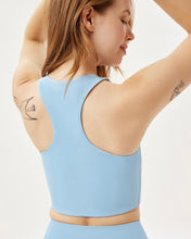 Load image into Gallery viewer, close up of the back of the Girlfriend Collective Paloma Bra in Cerulean on a model posing with her hands above her head
