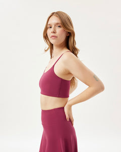 side view of the Girlfriend Collective Ultralight Juliet Bra in Rhododendron on a model posing with her hands on her hips