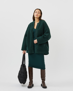 Minimum Women's Bavory Jacket in Pine Grove styled on a standing model over a green dress with knee high brown boots
