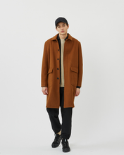 Load image into Gallery viewer, Front view of the Minimum Men&#39;s Balano Coat in Monks Robe worn open over a sweater on model
