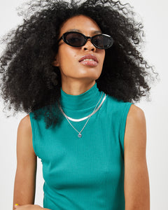 the Minimum Women's Mokka Top in Bayou on a model posing in sunglasses with her head tilted upwards