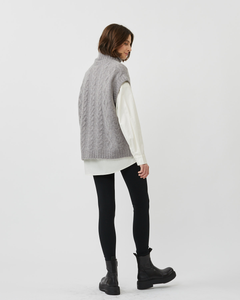 back view of the Minimum Women's Cablina Sweater Vest in Gull worn by a model standing 