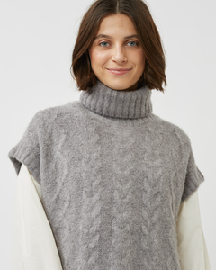 close up view of a model wearing the Minimum Women's Cablina Sweater Vest in Gull over a white long sleeve tee