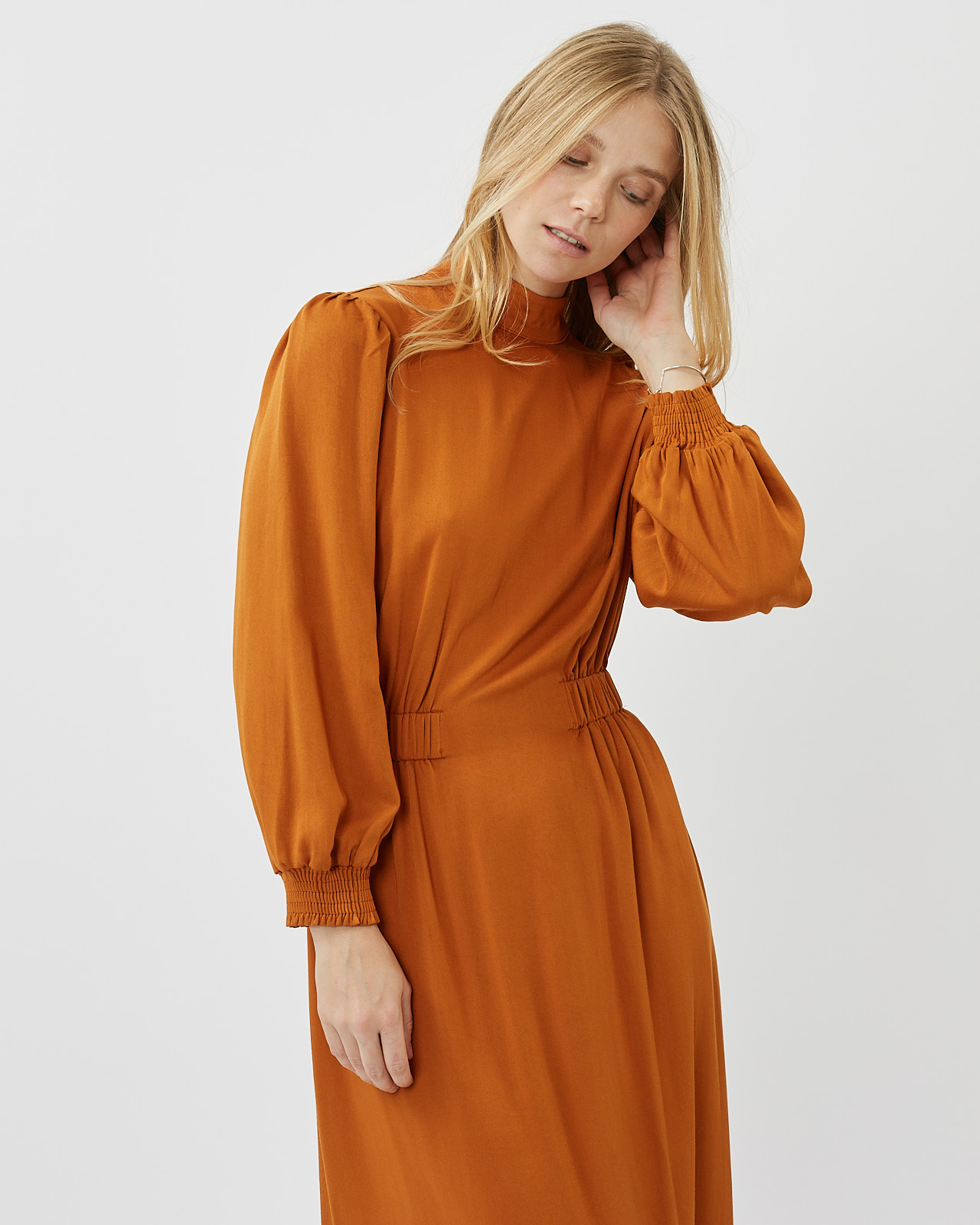 Minimum Women's Larada Midi Dress in Roasted Pecan worn by a model posing with her hand touching her ear